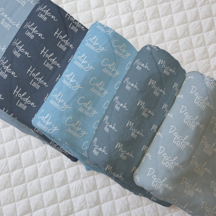 Assorted personalized blankets with names in shades of blue, showcasing custom design options.