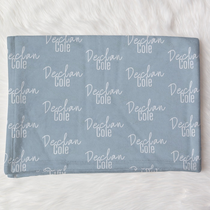 Folded blue personalized blankets with white script names, perfect for unique gifting.