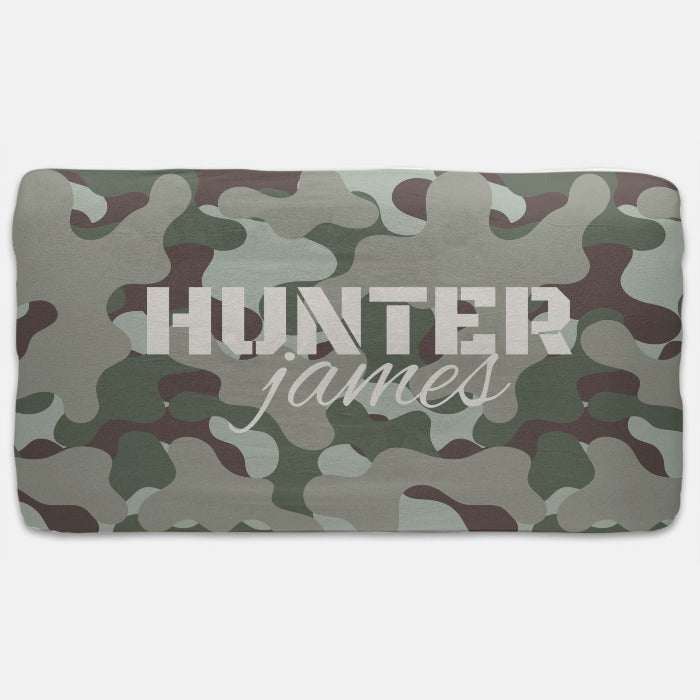 This cozy crib sheet showcases a classic camouflage design, offering both comfort and style with its blend of natural forest colors, designed to fit snugly over standard crib mattresses.