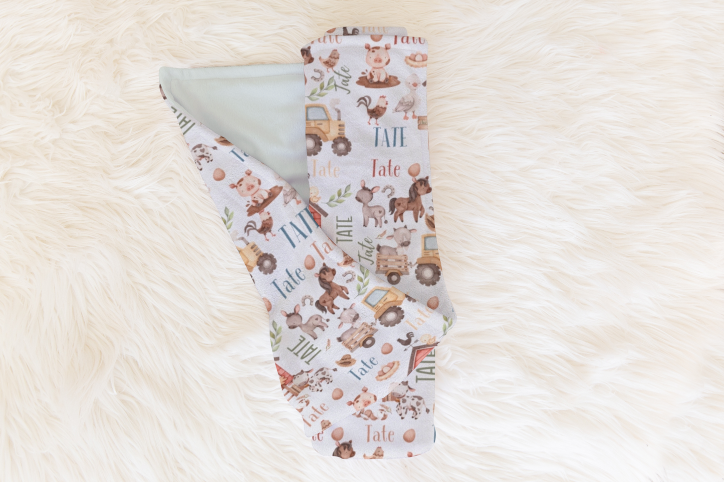 Charming baby blanket featuring farm animals and a customizable section to print a child’s name, suited for farm-themed nurseries