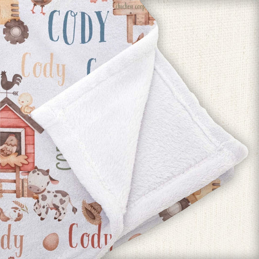 Soft and cozy baby blanket adorned with farm animal illustrations and a space for adding a child's name, making it a unique baby shower gift.